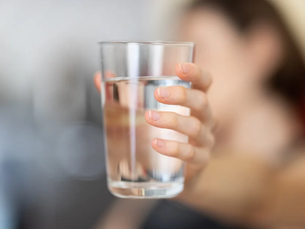 Γυναίκα κρατάει ποτήρι με νερό